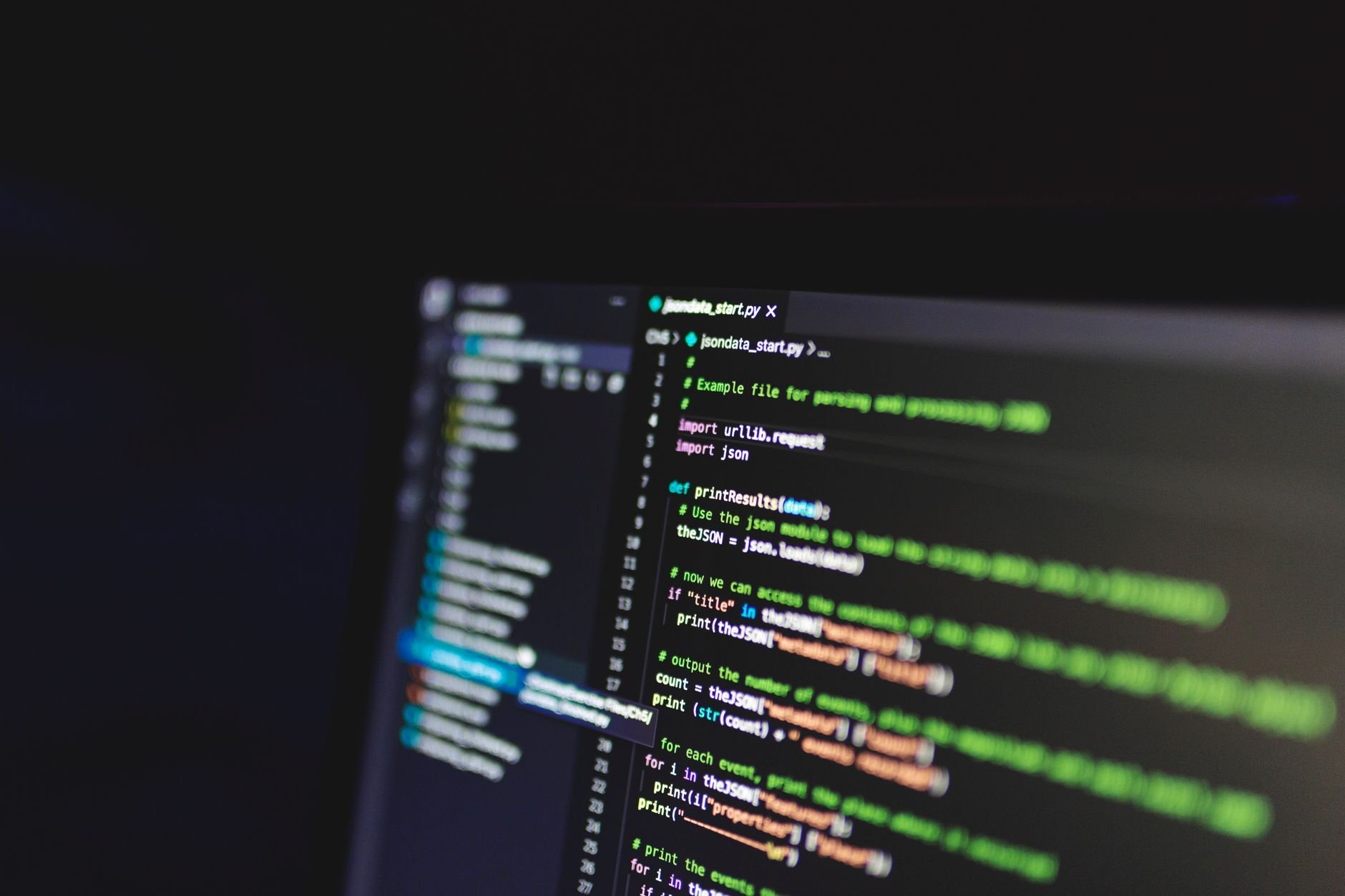 Programming code on a computer screen in a dark room, showcasing technology and IT expertise.
